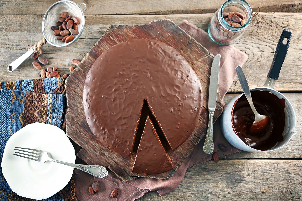 Sliced,Chocolate,Frosting,Cake,On,Wooden,Table