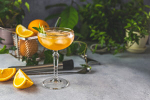 Champagne,Coupe,Glass,Of,Refreshing,Orange,Cocktail,With,Ice,Served