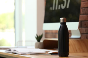 Modern,Black,Thermos,Bottle,On,Wooden,Desk,At,Workplace.,Space