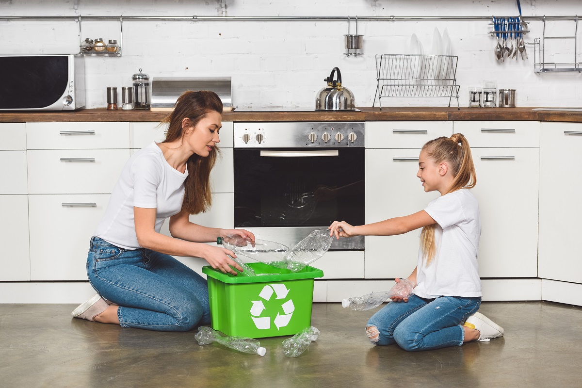 Mother,And,Daughter,Putting,Empty,Plastic,Bottles,At,Green,Recycle