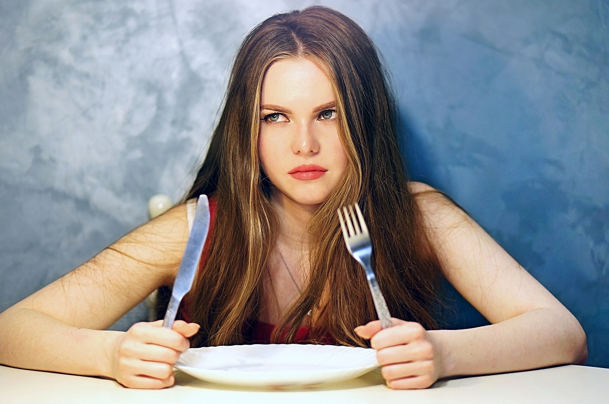 Hungry,Young,Woman,Waiting,With,An,Empty,Plate.
