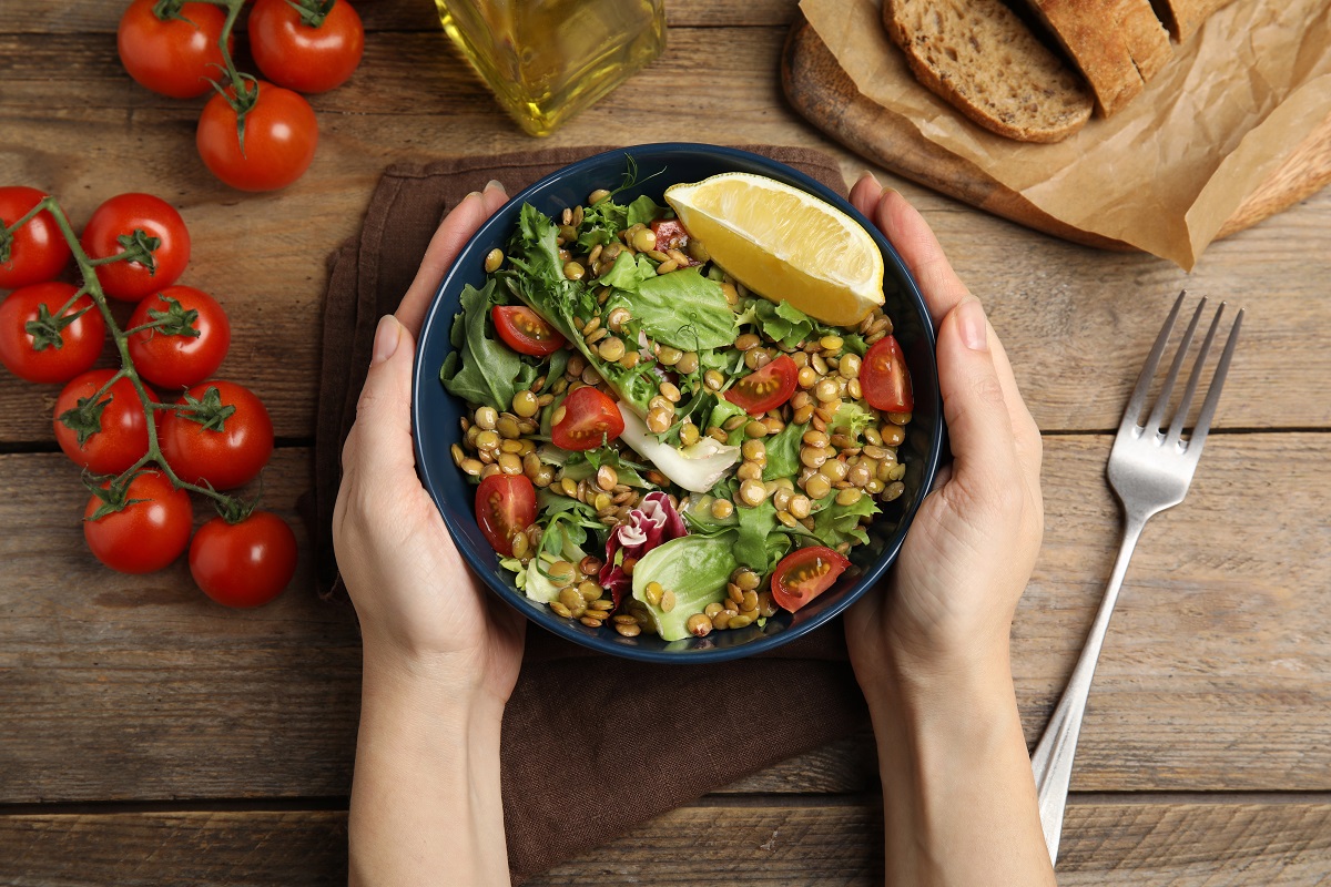 Woman,Holding,Bowl,Of,Delicious,Salad,With,Lentils,And,Vegetables