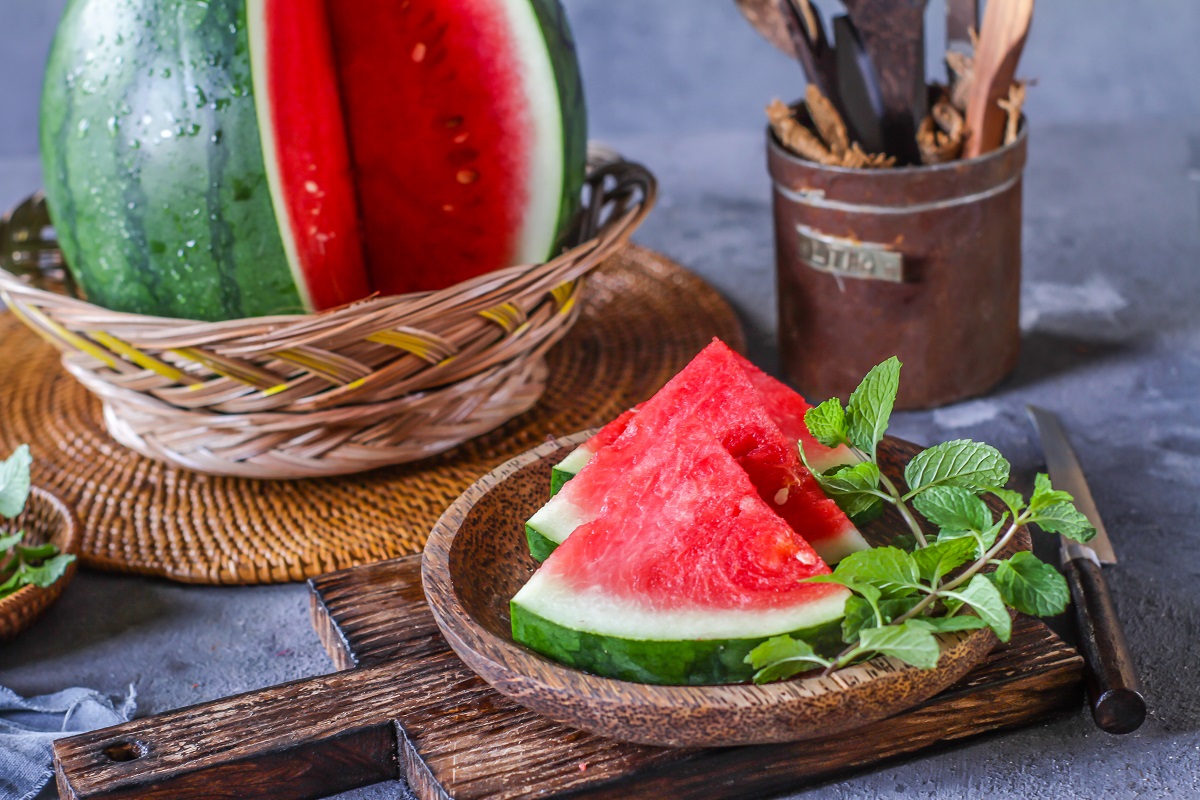 Photo,Of,Fresh,Watermelon,With,Green,Leaves,On,Wooden,Board