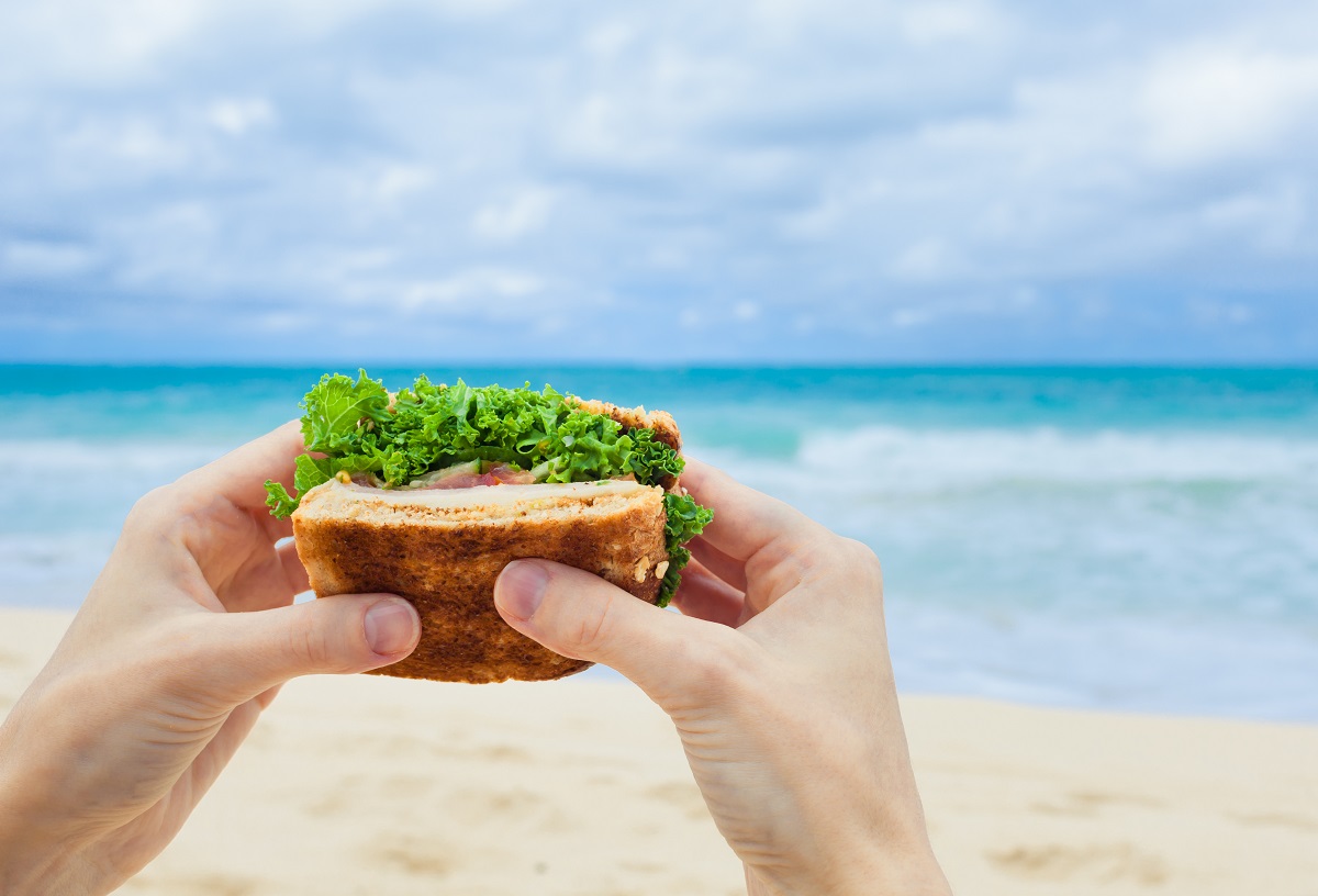 Woman,Holding,A,Healthy,Sandwich,On,The,Beach.,Healthy,Eating