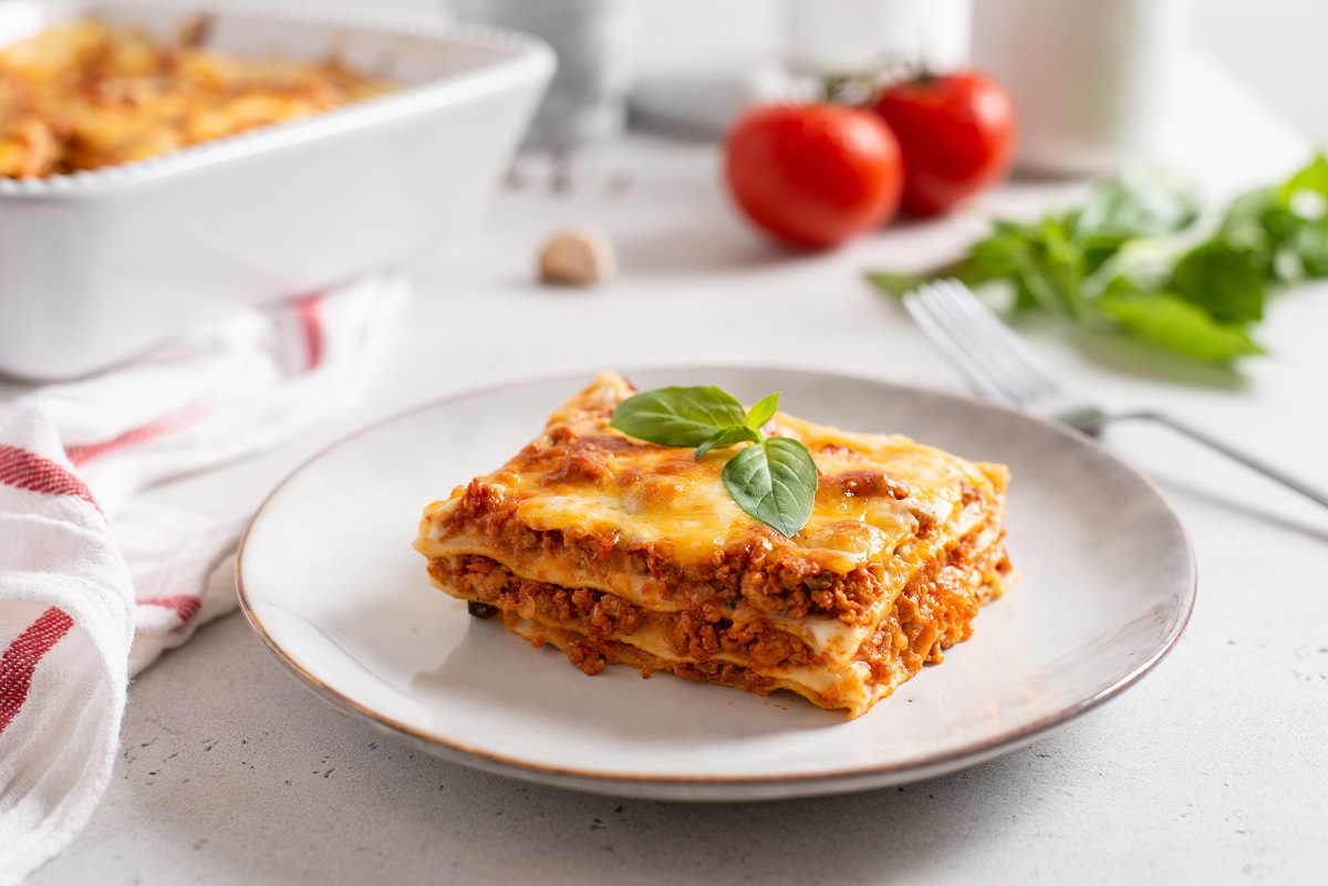 Piece,Of,Tasty,Hot,Lasagna,Served,With,A,Basil,Leaf