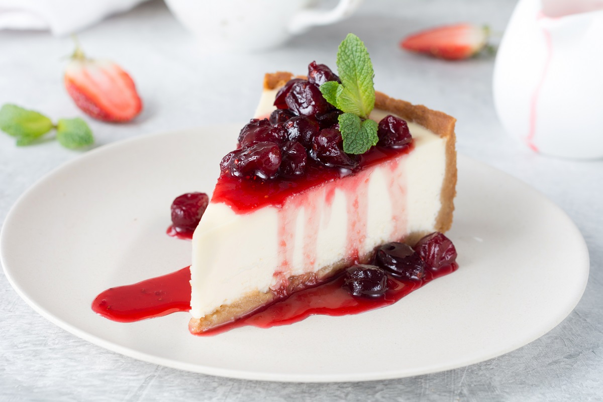 Slice,Of,Plain,Cheesecake,With,Cranberry,Sauce,On,White,Plate