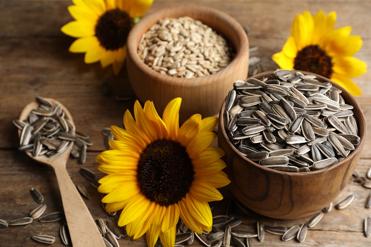 Organic,Sunflower,Seeds,And,Flowers,On,Wooden,Table