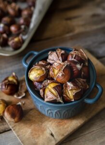 Oven,Roasted,Chestnuts,With,Sliced,Peel,On,Wooden,Board