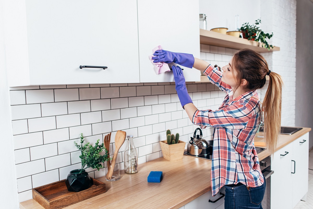Woman,In,Gloves,Cleaning,Cabinet,With,Rag,At,Home,Kitchen.