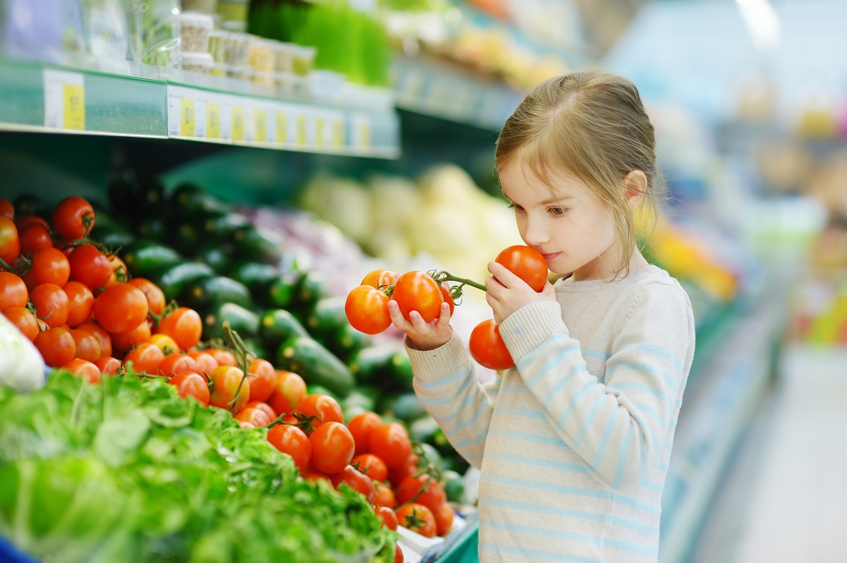 Little,Girl,Choosing,Tomatoes,In,A,Food,Store,Or,A