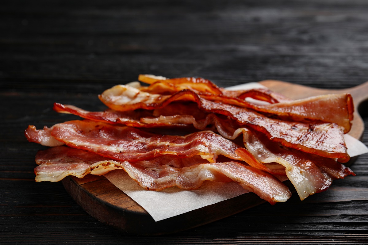 Slices,Of,Tasty,Fried,Bacon,On,Black,Wooden,Table,,Closeup