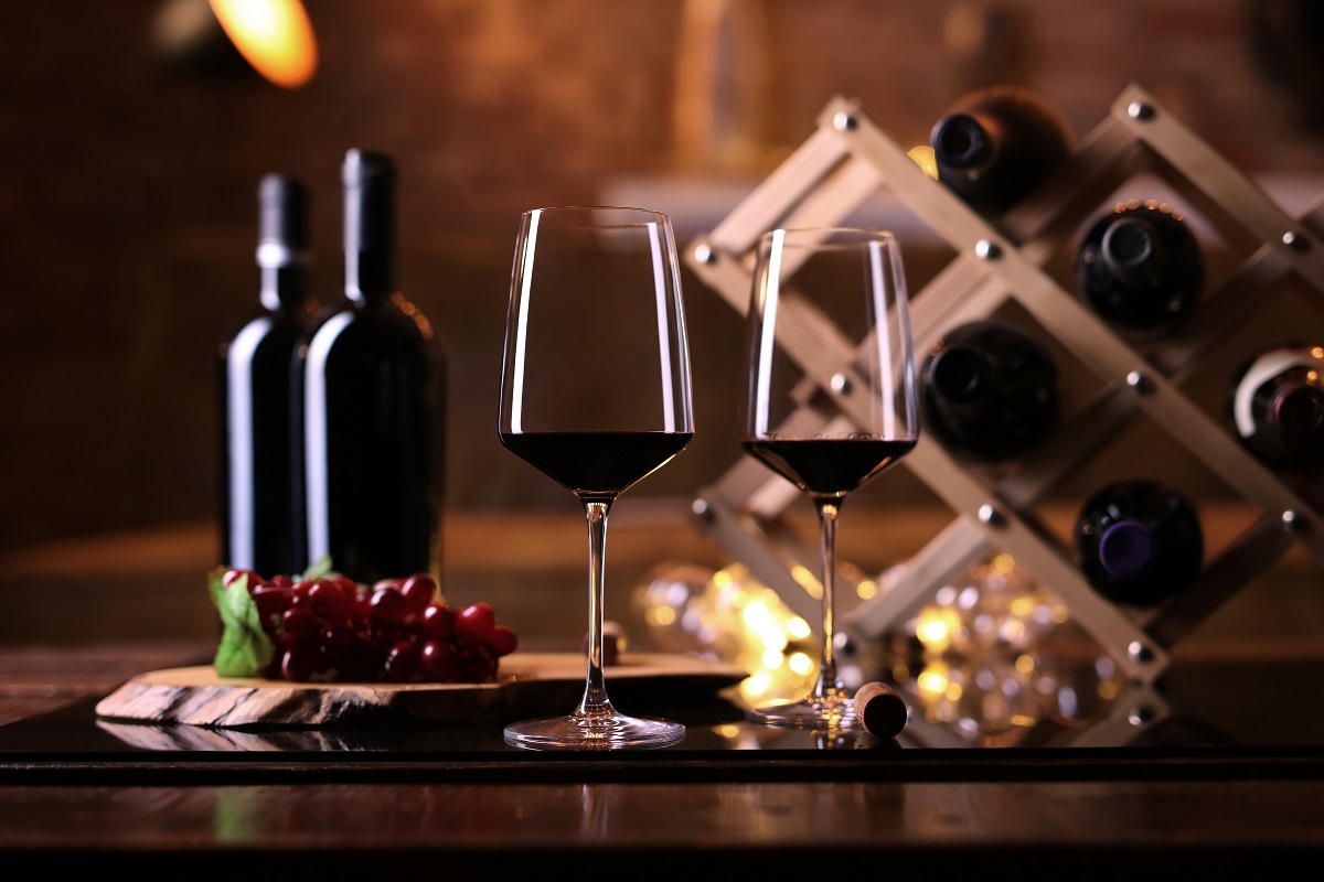 Glasses,Of,Red,Wine,On,Table,With,Wine,Bottle,Holder