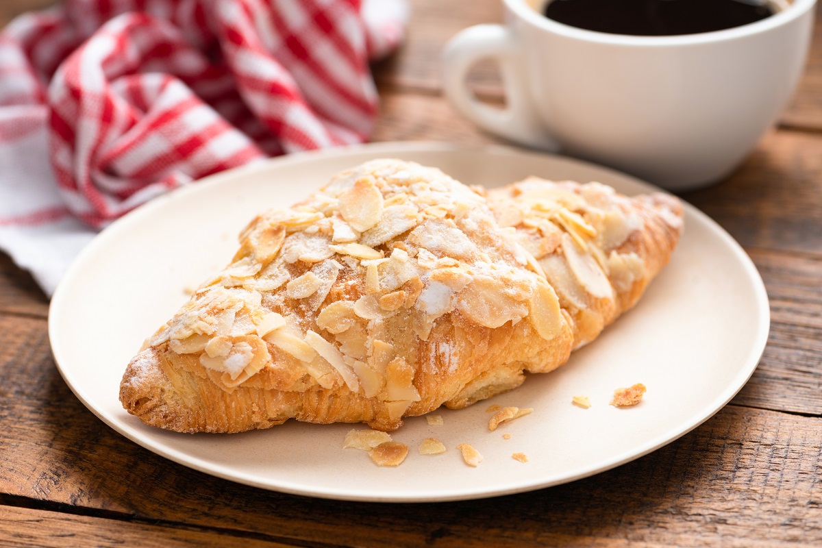 Almond,Croissant,On,A,Plate,Served,With,A,Cup,Of
