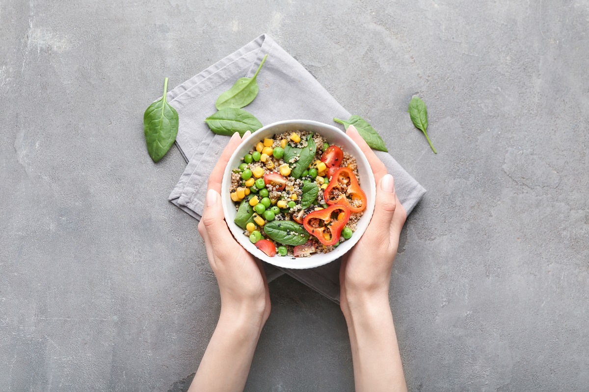 Female,Hands,With,Healthy,Quinoa,Salad,In,Bowl,On,Grunge