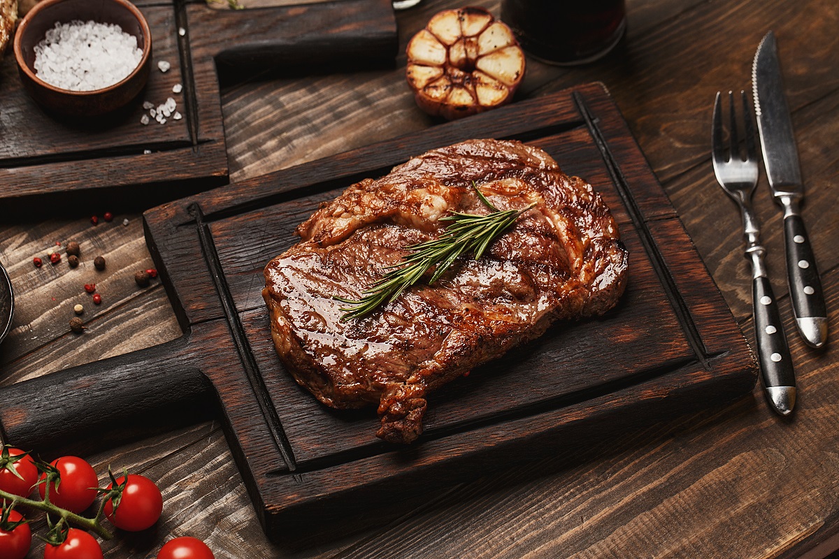 Grilled,Ribeye,Beef,Steak,Served,On,Wooden,Board,With,Rosemary,