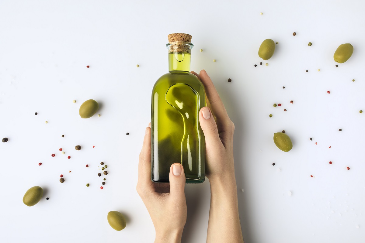 Cropped,Image,Of,Woman,Holding,Glass,Bottle,Of,Olive,Oil